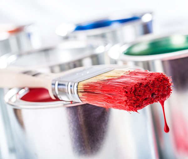 Pinsel mit roter Farbe und Farbdose
